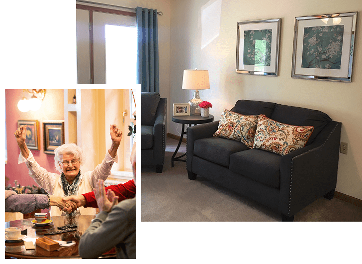 A cozy living room with a black sofa adorned with colorful patterned pillows, a side table with a lamp and framed photo, and two framed floral artworks on the wall. An inset shows an elderly woman smiling and raising her arms in celebration, shaking hands with someone at a table.